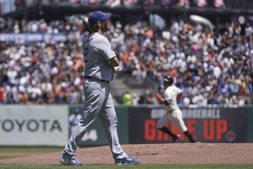 Clayton Kershaw, de los Dodgers de Los Ángeles, se lamenta después de que J.D. Davis (atrás), de los Gigantes de San Francisco le conectó un jonrón de dos carreras en el juego del jueves 4 de agosto de 2022 (AP Foto/Jeff Chiu)