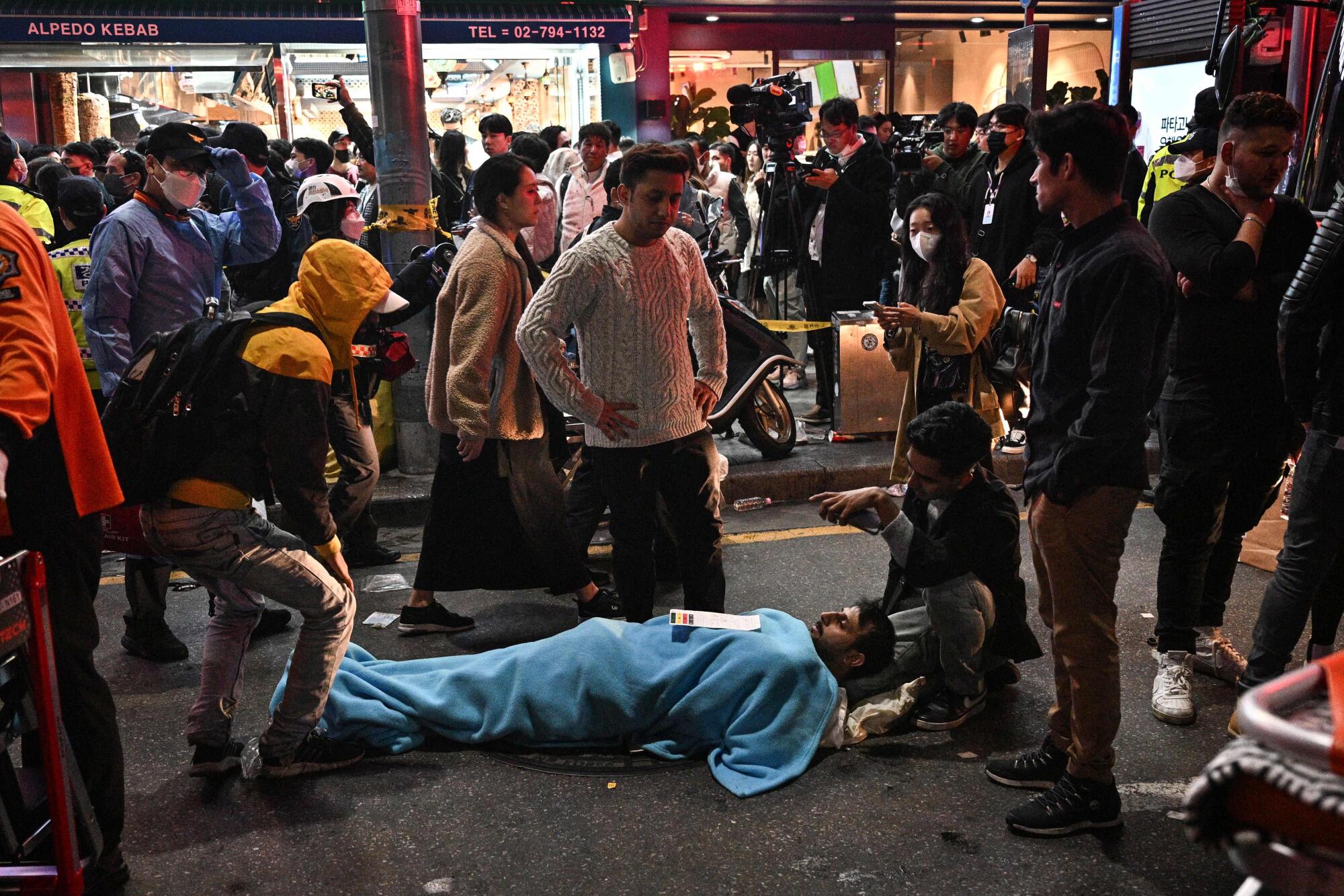 A man receives medical attention on the street.