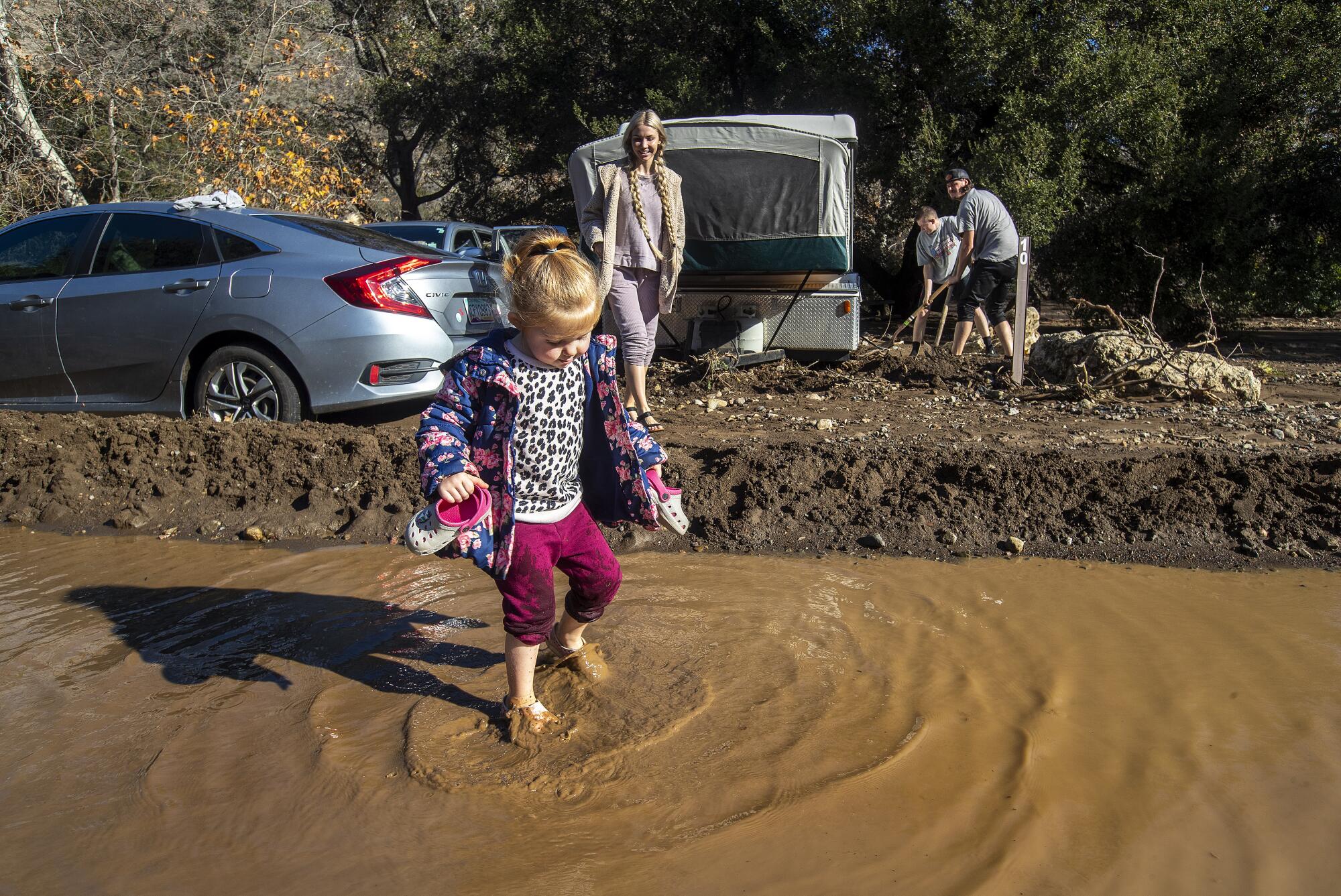 Nevaeh Allphin, 3, plays in a river of water from the recent rainstorm at Leo Carrillo State Campground in Malibu