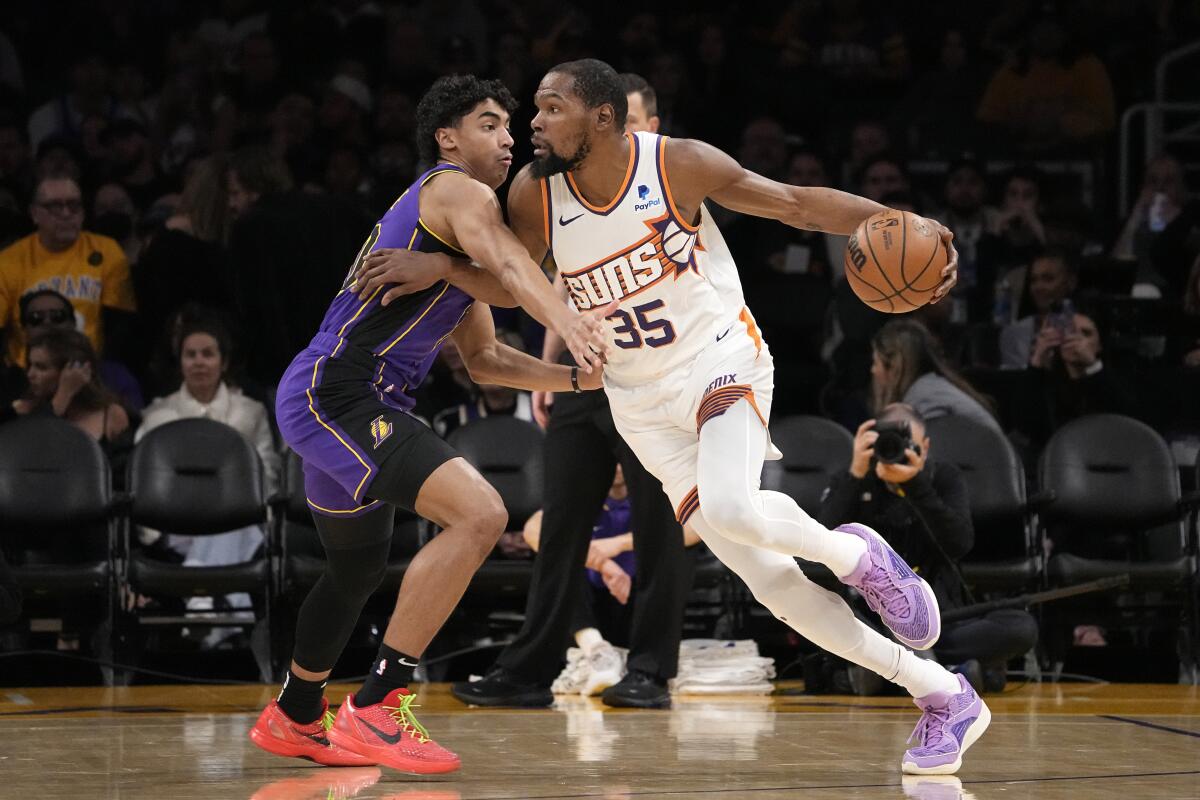 Kevin Durant, alero de los Suns de Phoenix, elude a Max Christie, de los Lakers de Los Ángeles,