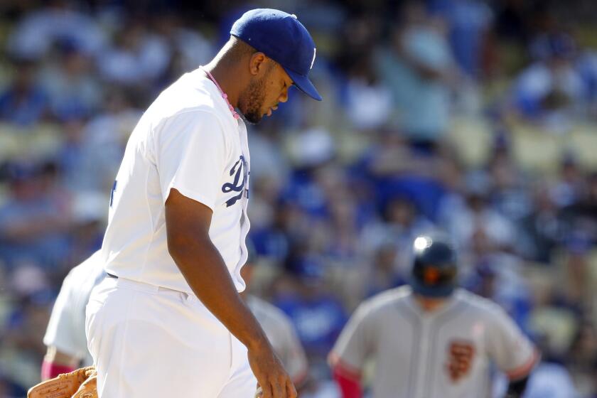 Dodgers closer Kenley Jansen walks back to the mound after giving up a run-scoring single in the 10th inning of the team's 7-4 loss to the San Francisco Giants on Sunday.