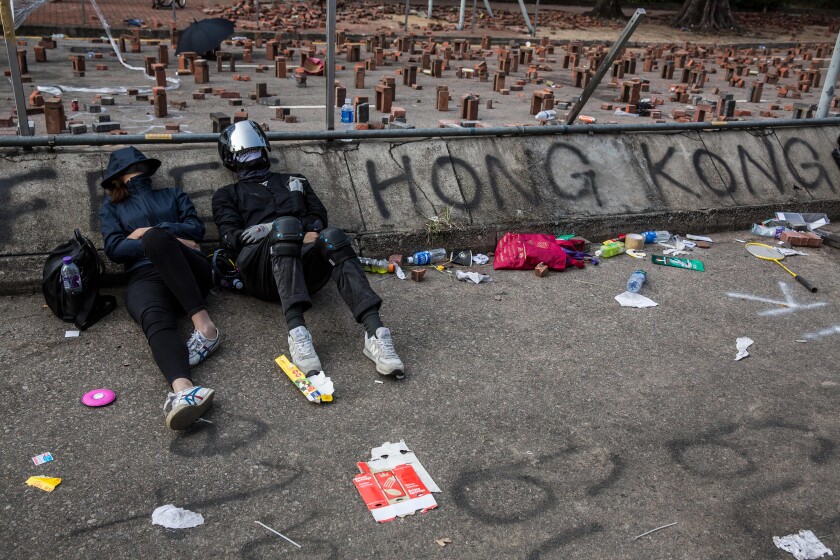 Protesters sleep on a barricaded street outside the Hong Kong Polytechnic University on Friday.