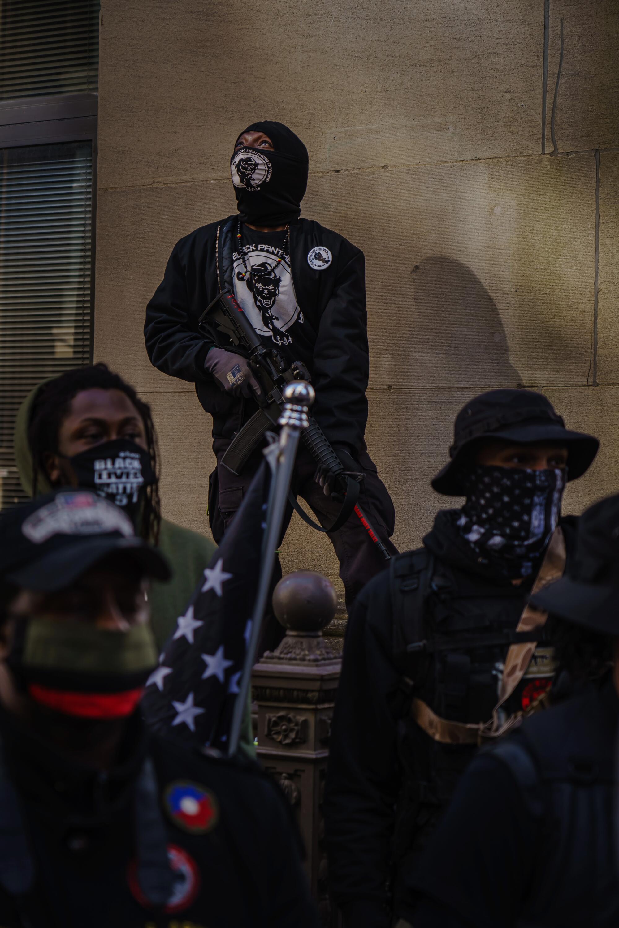 Members of the Virginia Black Panthers stand guard on a street corner.