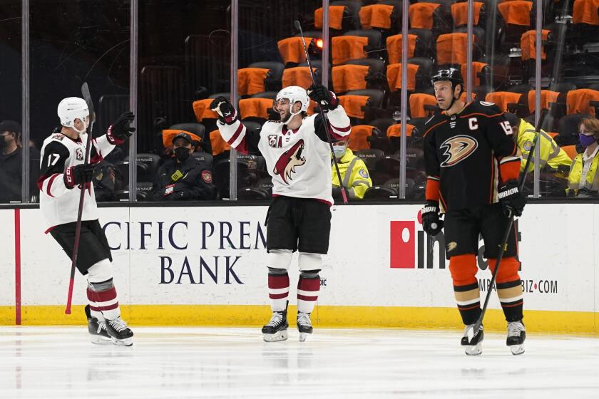 The Coyotes' Derick Brassard, center, celebrates a goal with Tyler Pitlick, left. The Ducks' Ryan Getzlaf is at right.
