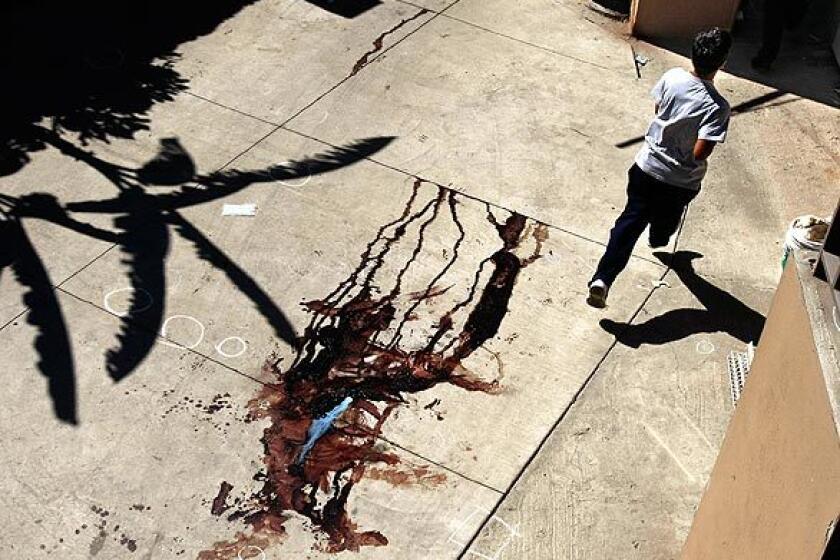 A teenager from a nearby school sprints through the blood-stained courtyard of a house in Tijuana where a Mexican soldier was killed during a shootout the night before.