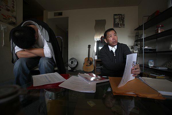 George Shi looks over paperwork as his son Will sits nearby in their San Gabriel home, from which they are working tirelessly to bring the killer of their daughter and sister Donglei to justice.