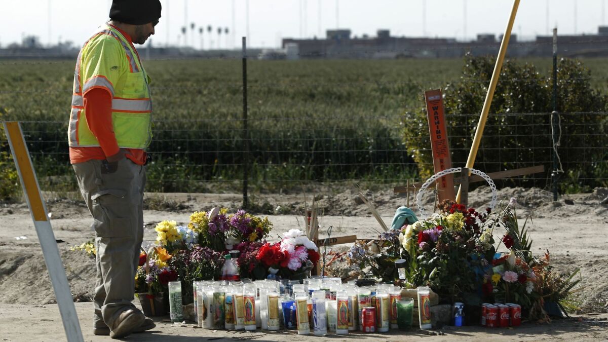 Ryan Reynoso, an employee with KRC Safety, looks at a memorial near the crash site on Cecil Avenue in Delano.