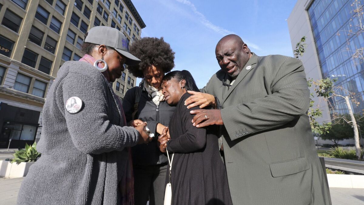 Lisa Hines, center, is comforted outside LAPD headquarters prior to a Police Commission meeting on the death of her daughter.