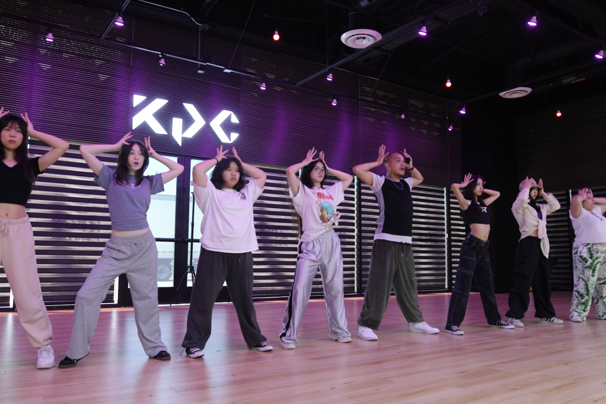 A line of people doing a dance in a studio.