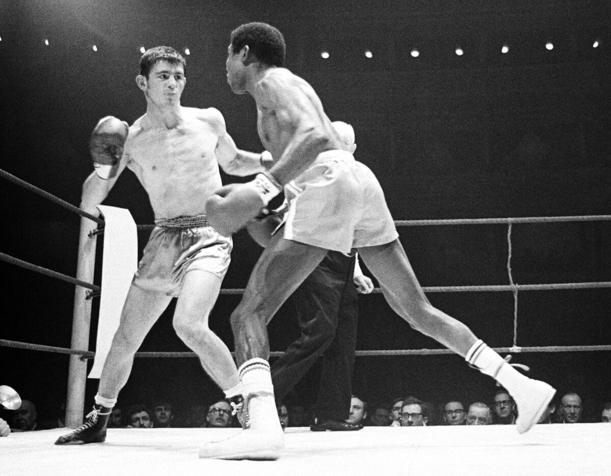 FILE - Cuban-born Spaniard Jose Legra, right, attempts to land a left hook to the head of French-born Australian boxer Johnny Famechon during their World Featherweight Title fight, at the Royal Albert Hall, London, on Jan. 21, 1969. Former boxing world champion Famechon has died in Melbourne after a lengthy illness. He was 77. The Sport Australia of Fame announced the death of Famechon in a statement on Thursday, Aug. 4, 2022. (AP Photo/Frank Tewkesbury, File)