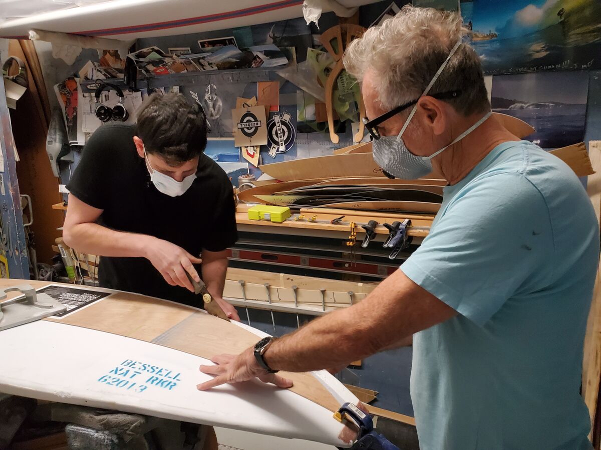 Daniel Seddiqui (left) stops in La Jolla during his national crafting tour to shape a surfboard with board maker Tim Bessell.