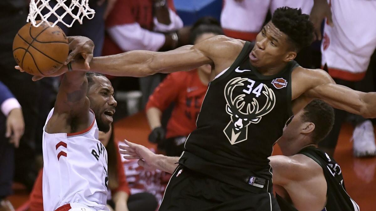 Milwaukee Bucks forward Giannis Antetokounmpo, right, blocks a dunk attempt by Toronto Raptors forward Kawhi Leonard during Game 6 of the Eastern Conference finals May 25.