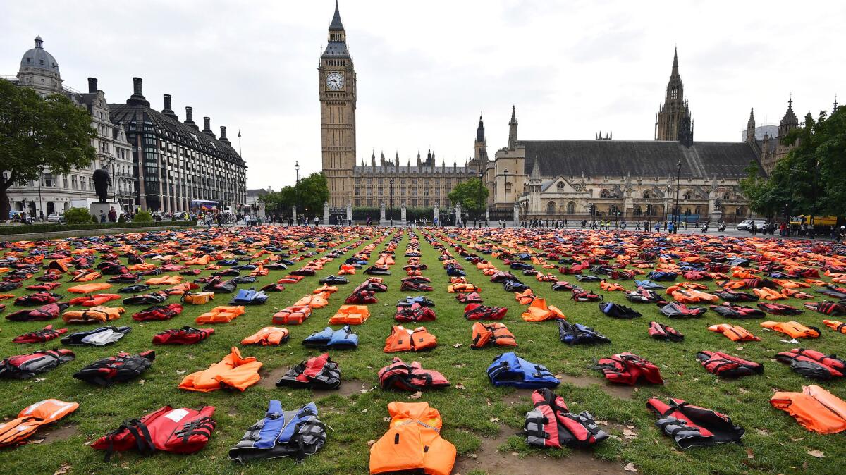 Lifejackets that have been used by refugees to cross the sea to Europe are laid out in Parliament Square in London on Monday.
