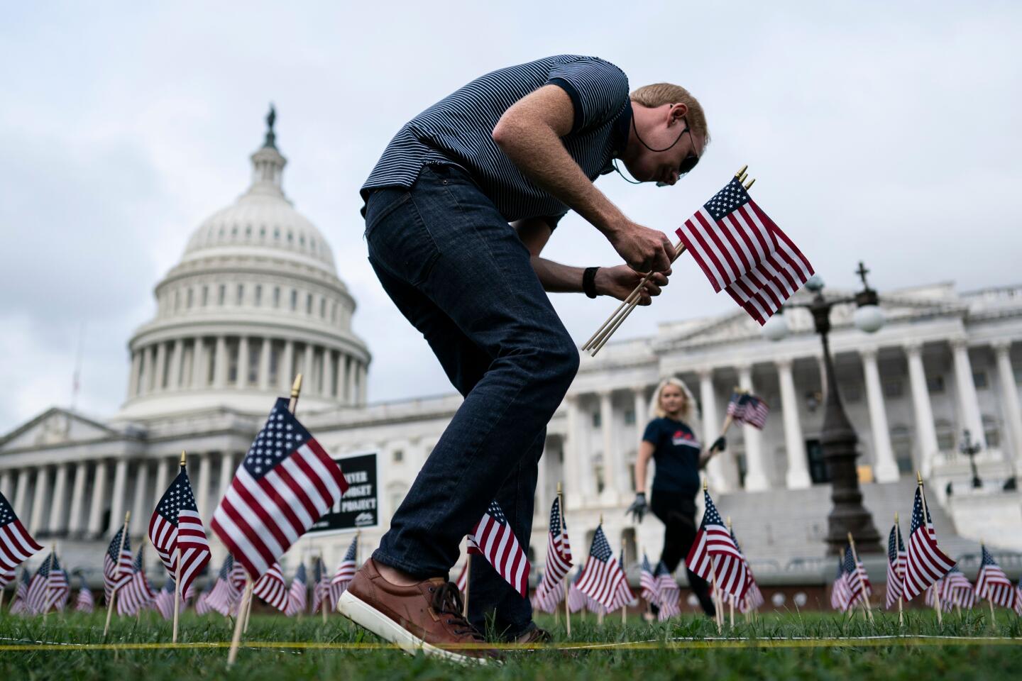 People place flags in the ground to honor the victims of the 9/11 attacks outside the U.S. Capitol