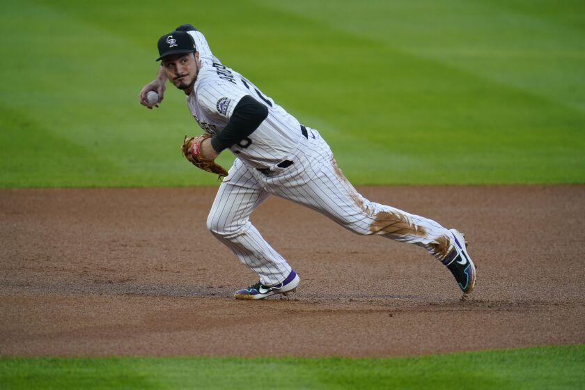 FILE - In this Sept. 11, 2020, file photo, Colorado Rockies third baseman Nolan Arenado throws to first during the first inning of the team's baseball game against the Los Angeles Angels in Denver. Arenado won his eighth consecutive Gold Glove on Tuesday, Nov. 3, 2020. (AP Photo/David Zalubowski, File)