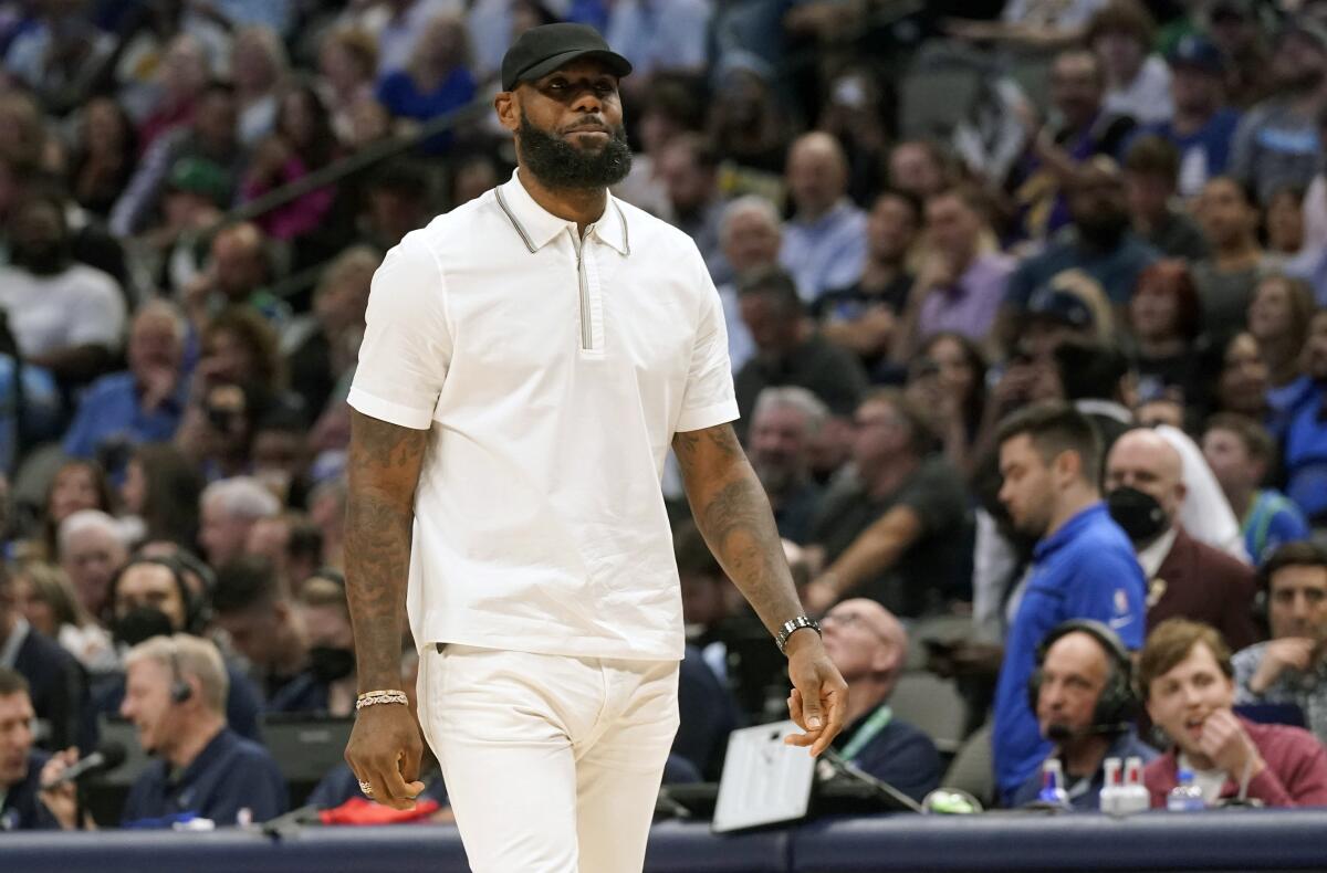 Lakers forward LeBron James walks the floor in street clothes during a game against the Mavericks on Tuesday in Dallas.