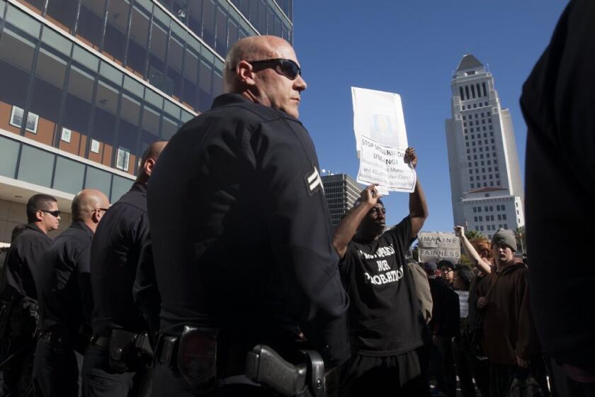 Protesters and police are seen during a rally at Los Angeles Police Department headquarters against the fatal shooting of an unarmed homeless man on Sunday in downtown L.A.'s skid row.