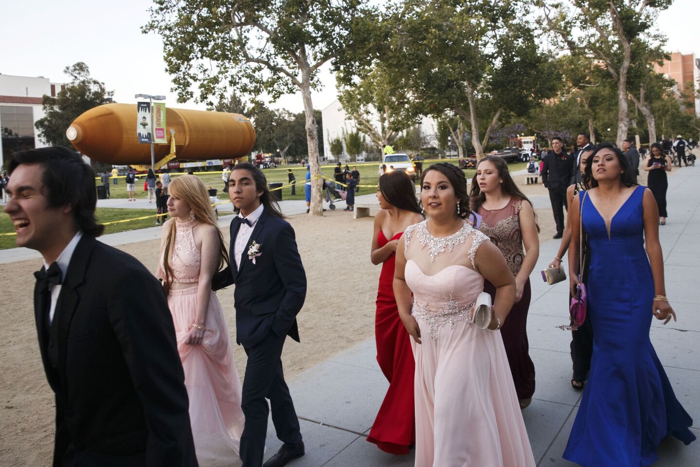 High school students from Downey walk to prom as the ET-94 fuel tank rests outside the California Science Center.