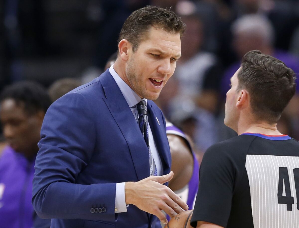Sacramento coach Luke Walton talks with referee Ben Taylor during a game against the Hornets on Wednesday.