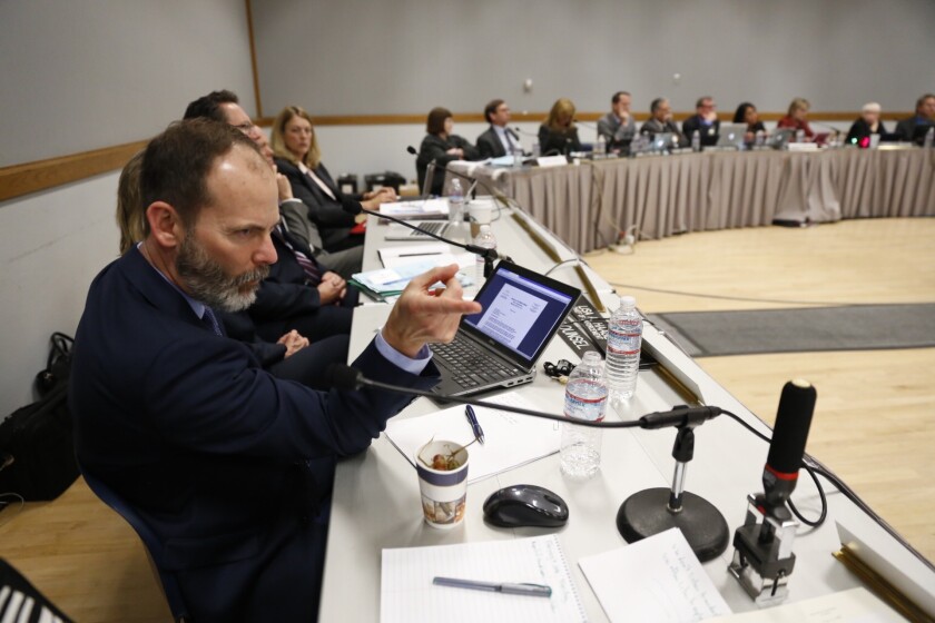 Charles Lester, left, executive director of the California Coastal Commission, reacts as speakers discuss whether he should be fired at the commission meeting last week in Morro Bay. The panel voted to dismiss him.