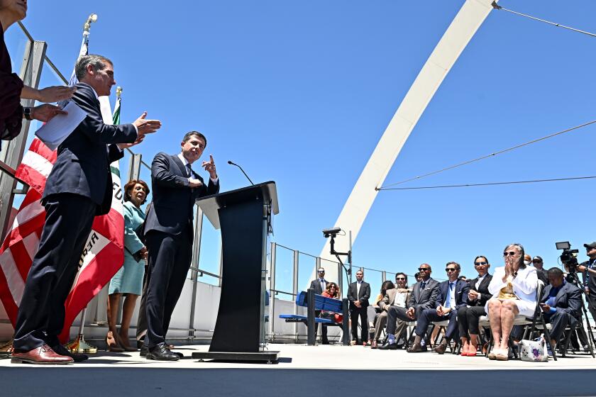 Los Angeles, California July 7, 2022-U.S. Transportation Secretary Pete Buttigieg, speaks during a press conference at LAX Thursday as L.A. Mayor Eric Garcetti, left, looks on. (Wally Skalij/Los Angeles Times)