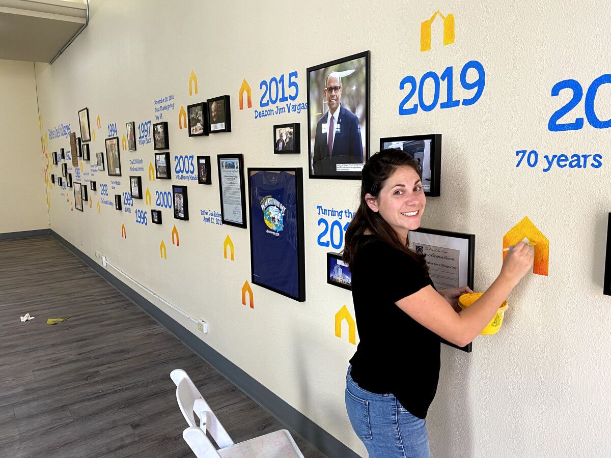 Ocean Beach resident Diane Lehman works on a history timeline mural she painted for Father Joe's Villages' 70th anniversary.