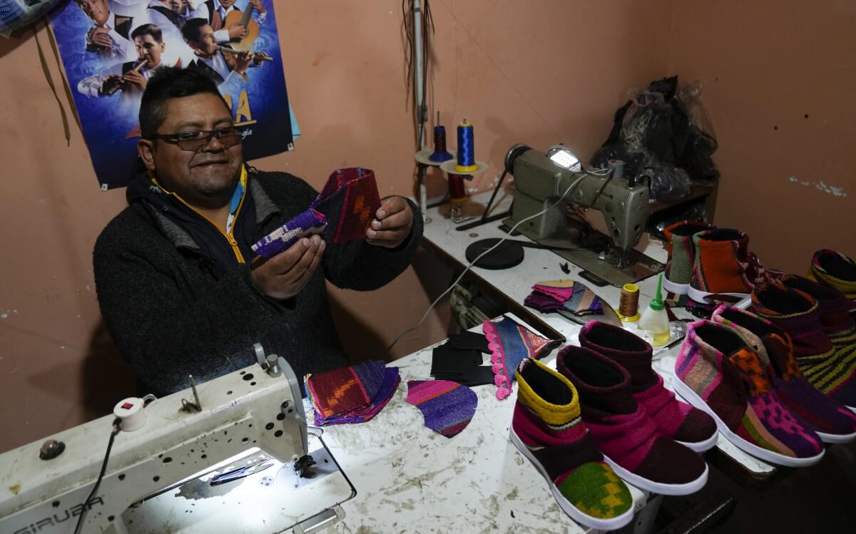 Lidio Herbas trabaja en su taller de calzado con tejidos de los Andes en El Alto, Bolivia, 