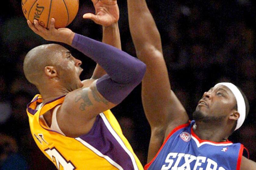 Kobe Bryant shoots over former teammate Kwame Brown on Jan. 1, 2012. Brown was waived by the Philadelphia 76ers on Wednesday.