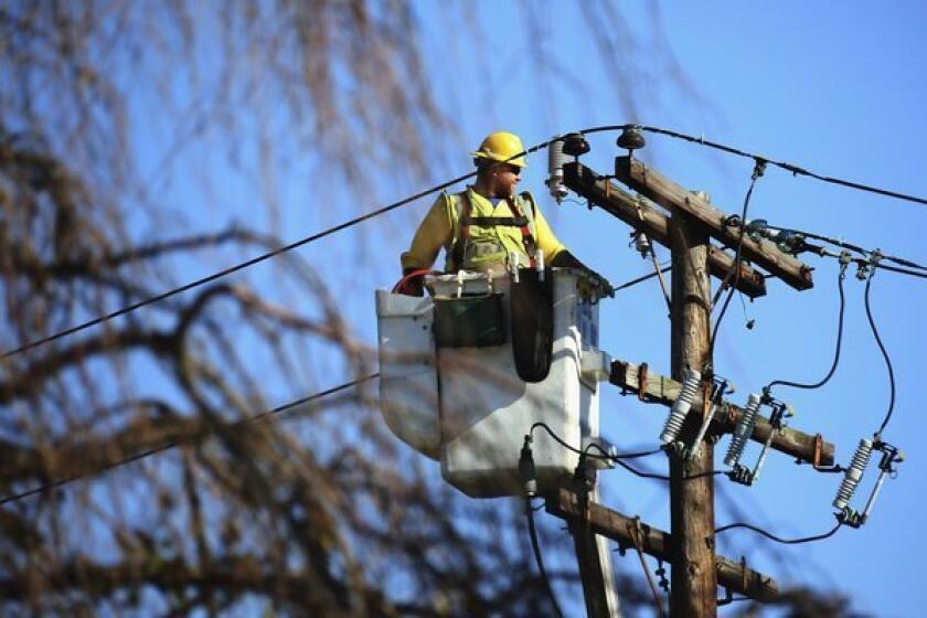 A worker positions himself to repair electrical lines as Long Islanders continue their cleanup efforts in the aftermath of Superstorm Sandy.