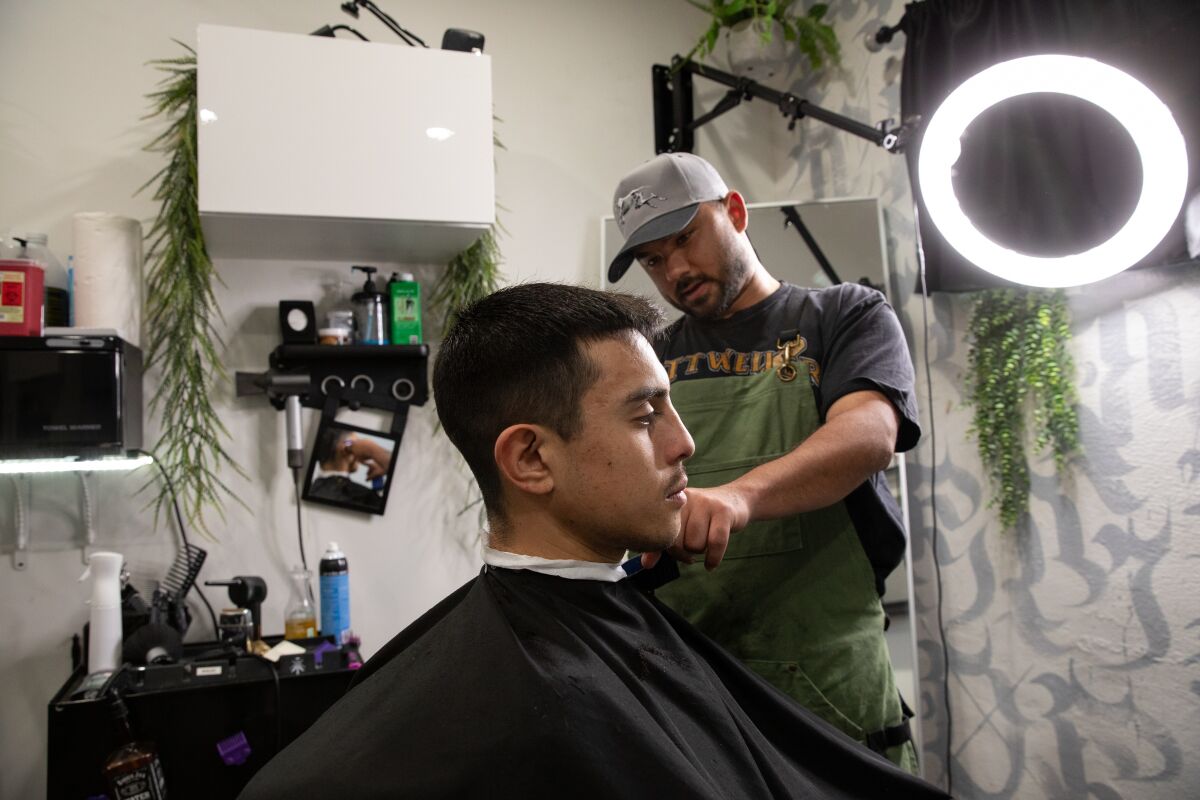 Eric Vega, the owner of SoLaced Barbershop in 1835 Studios, cuts Adrian Gutierrez's hair on March 1.