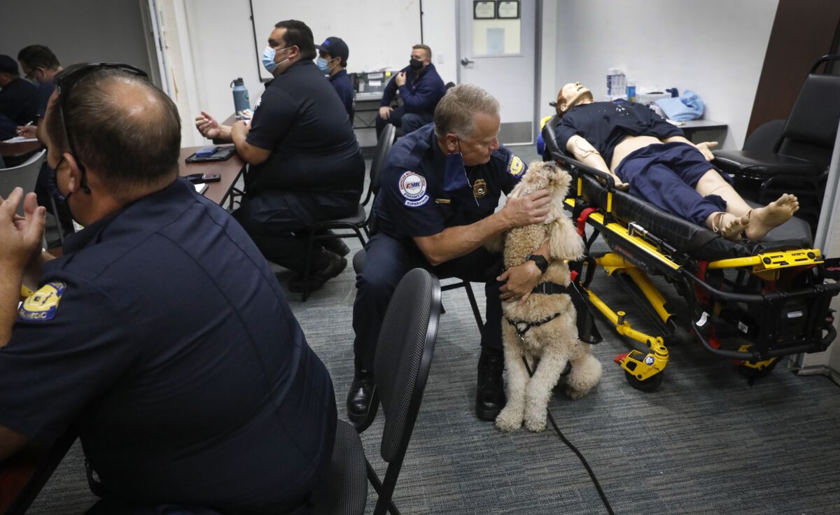 Baxter the therapy dog meets with medics and and other staff including Todd Hombs, a paramedic supervisor.