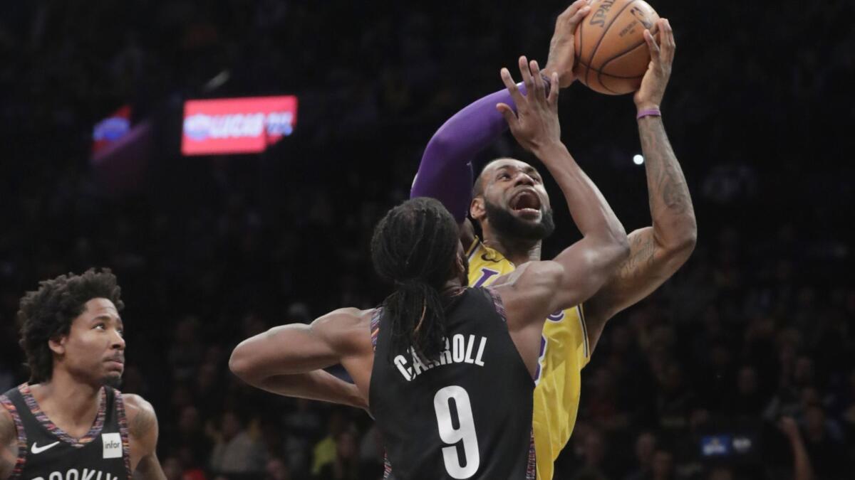 Lakers' LeBron James drives past Brooklyn Nets' DeMarre Carroll (9) during the first half on Tuesday in New York.