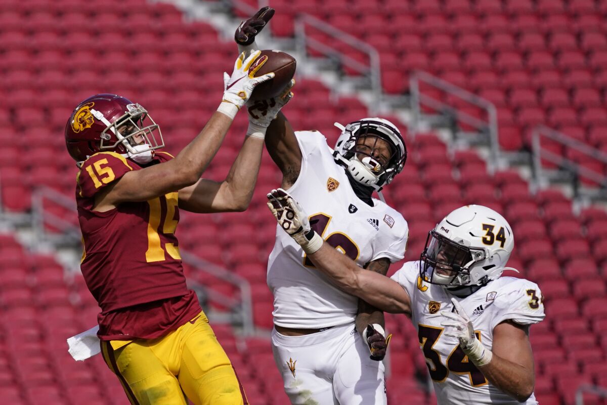 CORRECTS TO SECOND HALF, NOT FIRST HALF - Southern California wide receiver Drake London (15) catches a pass in the end zone for a touchdown as Arizona State defensive back Kejuan Markham (12) and linebacker Kyle Soelle (34) defend during the second half of an NCAA football game Saturday, Nov. 7, 2020, in Los Angeles. USC won 28-27. (AP Photo/Ashley Landis)