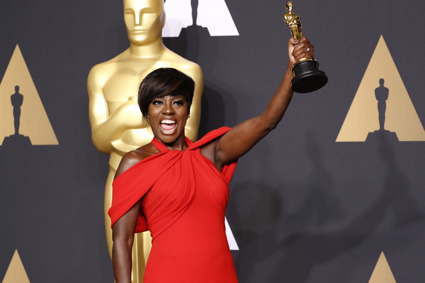 "Fences" star Viola Davis hoists her award for supporting actress backstage in the photo room at the 89th Academy Awards on Feb. 26 at the Dolby Theatre in Hollywood.
