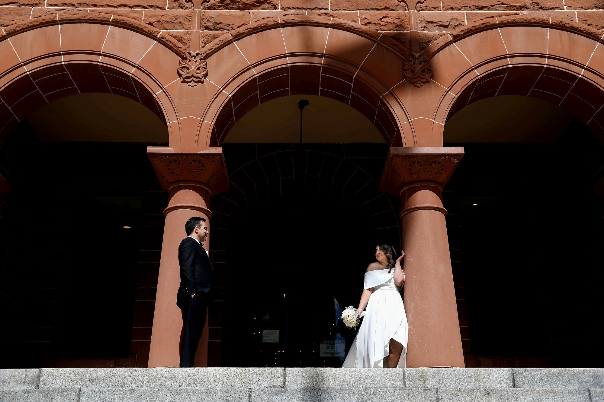 A couple pose for photos outside the courthouse before their nuptials.