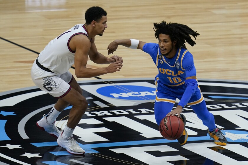 UCLA guard Tyger Campbell dribbles past Gonzaga guard Jalen Suggs