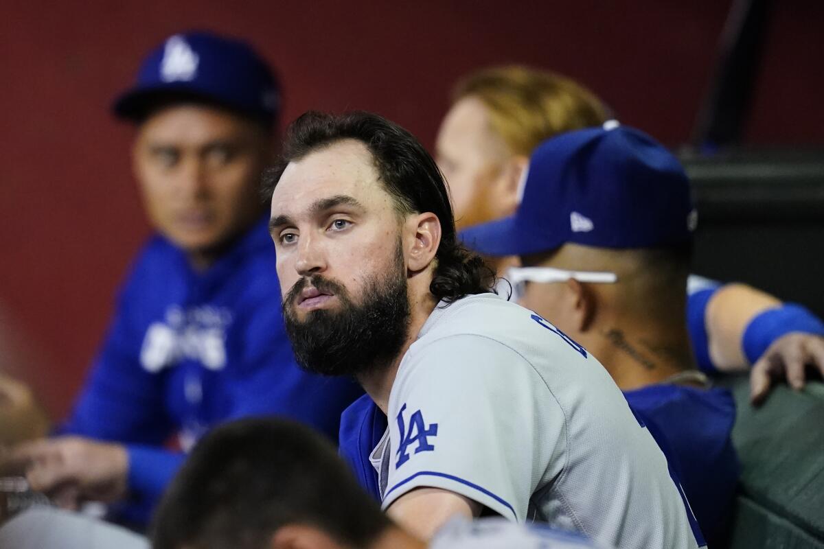 Dodgers pitcher Tony Gonsolin sits in the dugout with teammates.