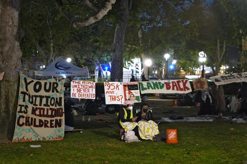 Gente montando guardia ante un campamento de manifestantes propalestinos en el campus en la Universidad del Sur de California, el sábado 4 de mayo de 2024 en Los Ángeles. (AP Foto/Ryan Sun)