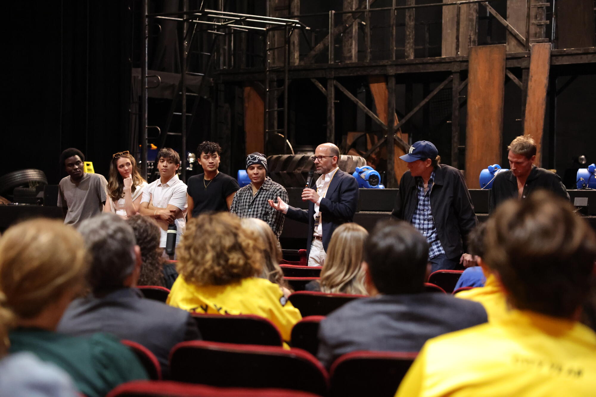 A group of theater makers in front of a stage.