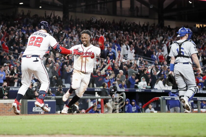 The Braves' Ozzie Albies, right, celebrates with ex-Dodger Joc Pederson after scoring.