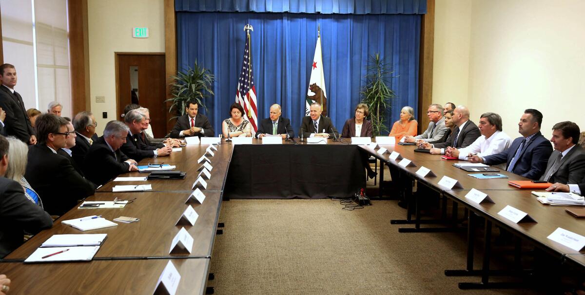 Gov. Jerry Brown, center, listens to the discussion of a proposed water bond measure during a meeting with lawmakers and interest groups at the Capitol on Aug. 12.
