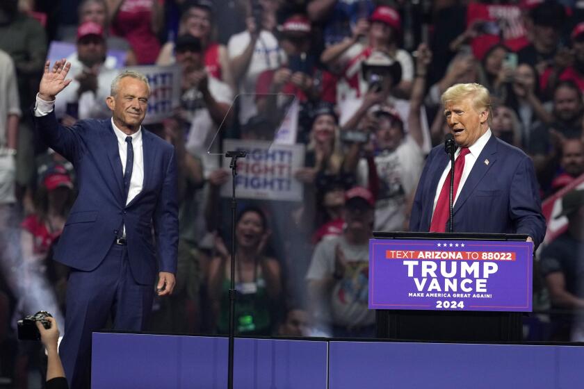 Independent presidential candidate Robert F. Kennedy Jr., left, waves to the crowd as Republican presidential nominee former President Donald Trump speaks at a campaign rally Friday, Aug. 23, 2024, in Glendale, Ariz. (AP Photo/Ross D. Franklin)