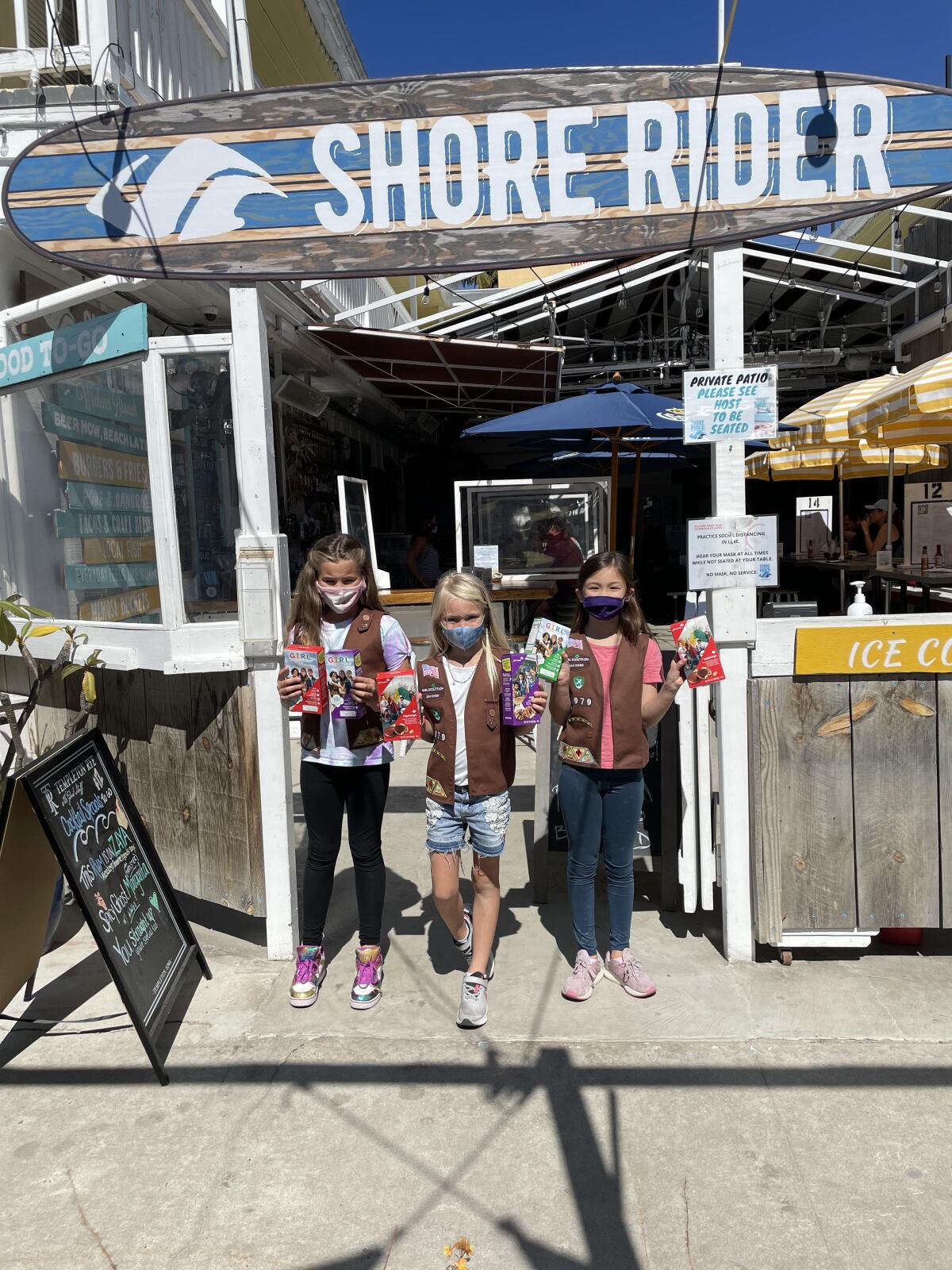 Girl Scout Brownie troop members at their pop-up cookie shop at Shore Rider in La Jolla.