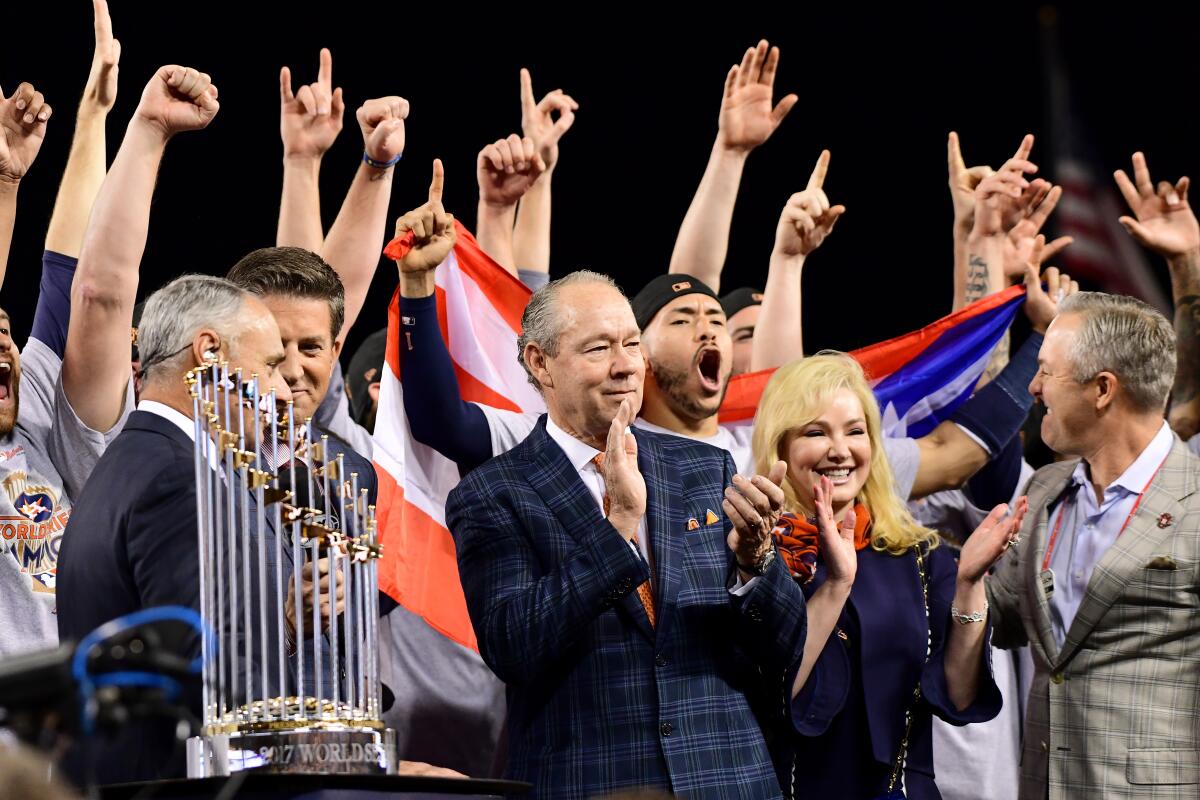Houston owner Jim Crane stands with the Commissioner's Trophy after the Astros' victory over the Dodgers in Game 7 of the 2017 World Series on Nov. 1, 2017.