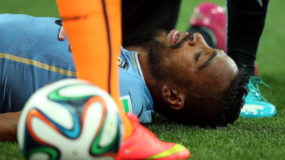 Uruguay's Alvaro Pereira lies on the field after taking a knee to the head during Thursday's World Cup victory over England. Despite the team doctor's objections, Pereira reentered the game.