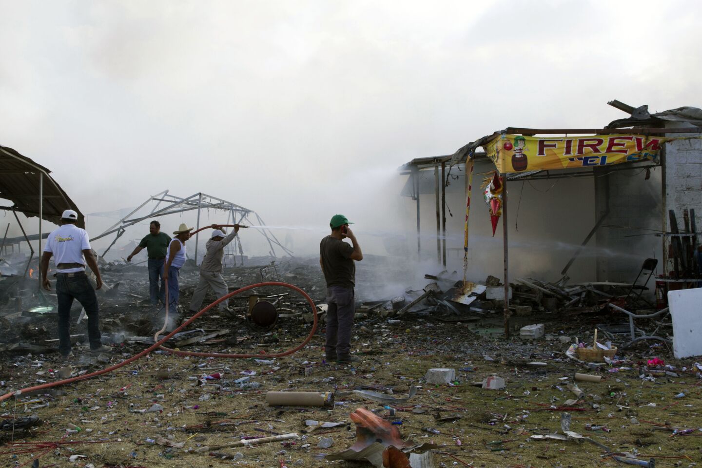 Firefighters and volunteers work at the site of a series of explosions at at fireworks market north of Mexico City.