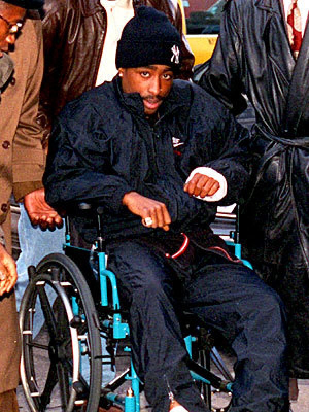 A bandaged Shakur rolls into court in a wheelchair on Dec. 1, 1994, the day after the Quad shooting -- having signed himself out of the hospital against doctors' advice. In court, he was convicted of first-degree sexual abuse in a rape case involving a 19-year-old fan.