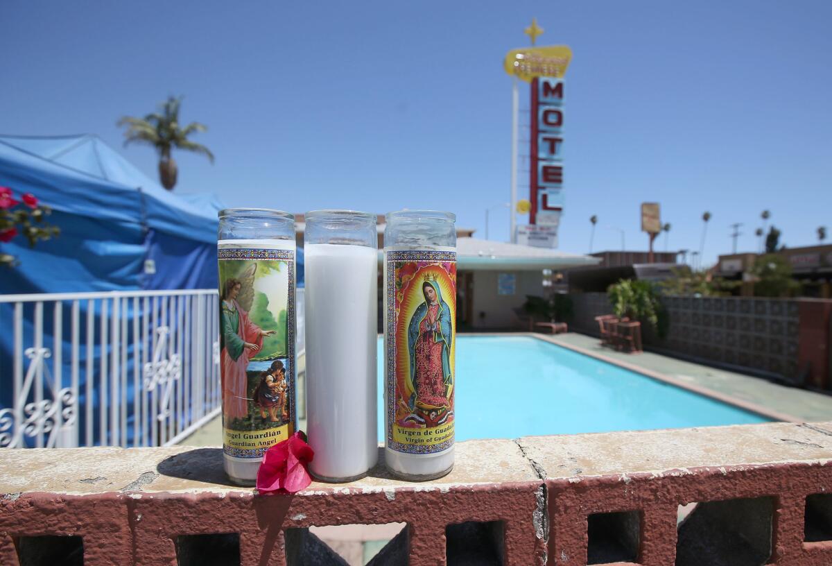 Memorial candles are placed on a wall at the pool area of the Hollywood Premiere Motel where a mother and two of her children were pulled from the water.
