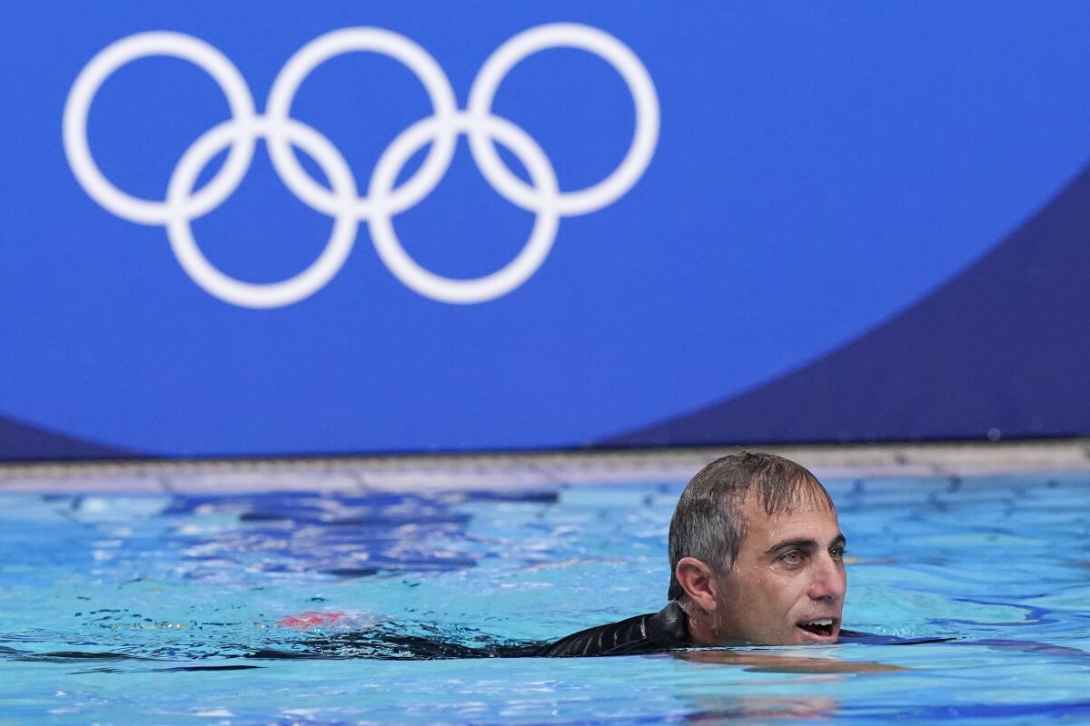 U.S. women's water polo coach Adam Krikorian swims in the pool after his team beat Spain 14-5 to win the gold medal.