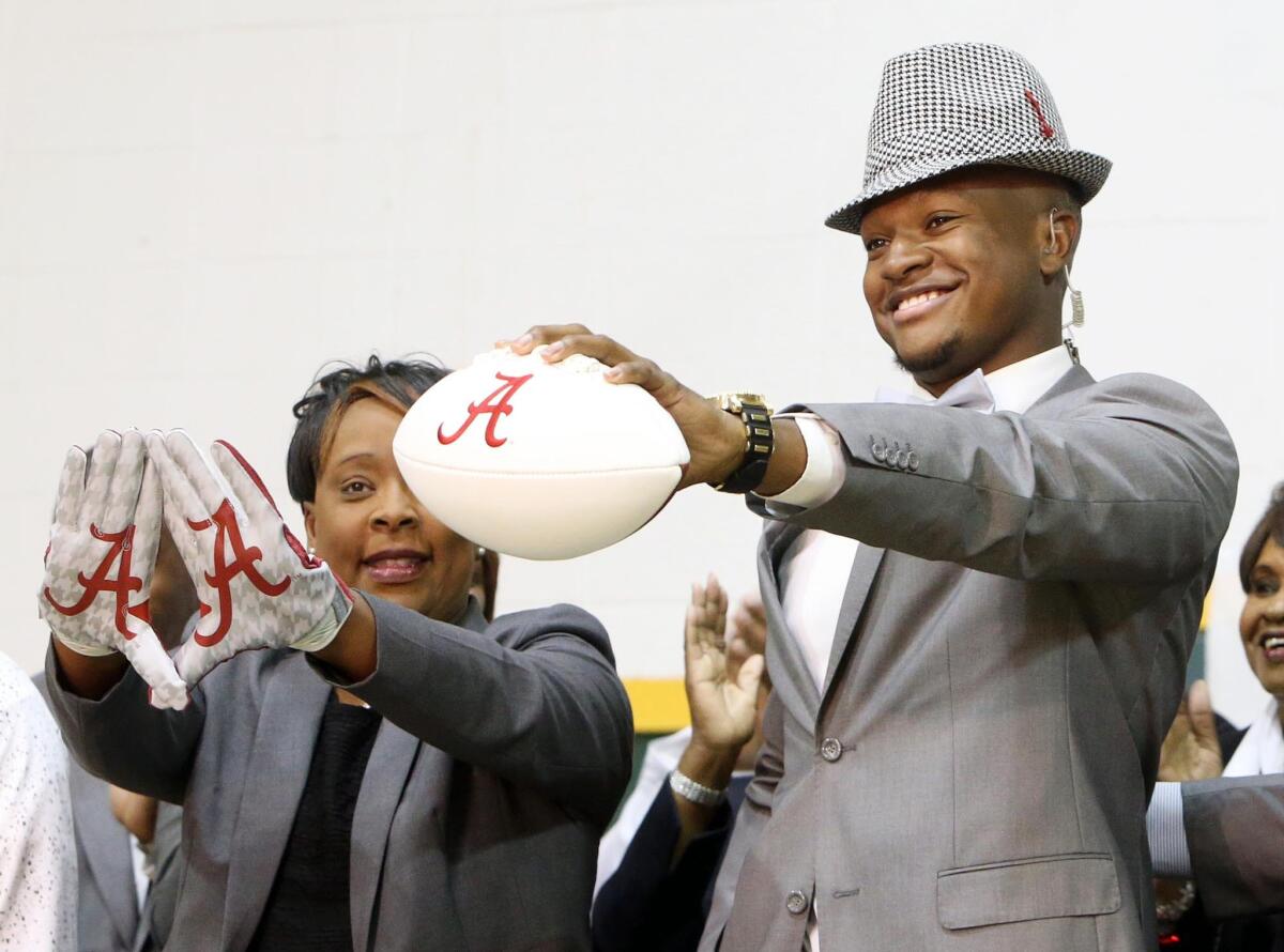 Gordo High (Ala.) football player Ben Davis holds up a football with the Alabama symbol on national signing day while dressed like legendary Crimson Tide coach Bear Bryant.